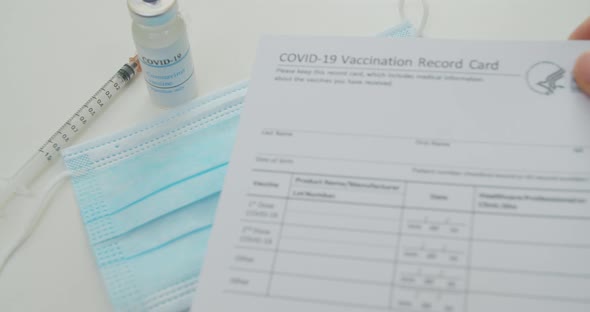 Medical Mask and COVID19 Vaccine Doctor Hand Put Vaccination Record Card Approved By CDC with Corona alt