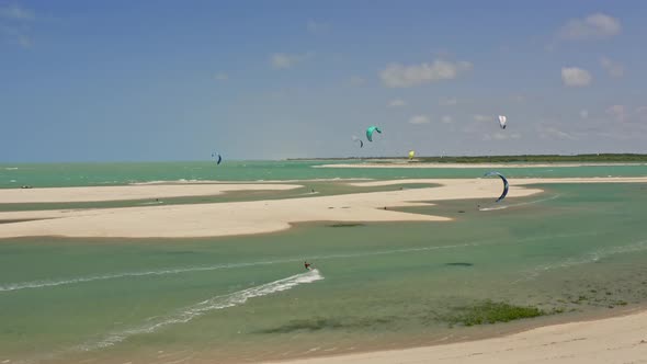 Brazilian kite surfer in high speed jumping with several kites in background alt