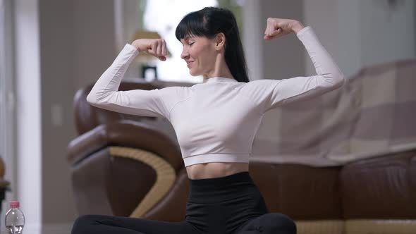 Happy Satisfied Sportswoman Showing Strength Gesture Smiling Looking at Camera alt