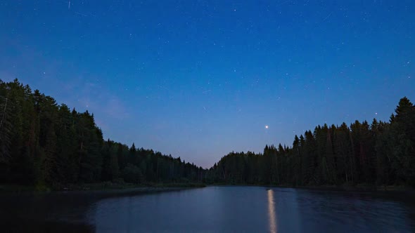 Night Sky with Clouds Illuminated By Stars Over a Mountain Lake and a Trees Silhouette alt