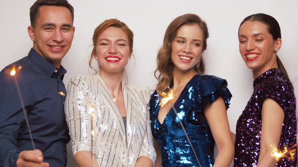 Happy Friends with Sparklers Dancing at Party alt