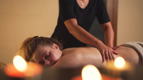 A Masseuse Gives a Client a Back Massage in a Massage Spa