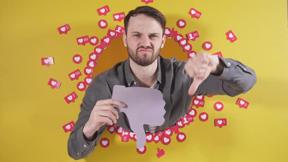 A Frustrated Person Holds a Sign with His Thumb Down He is Sad That He Has a Lot of Dislikes alt