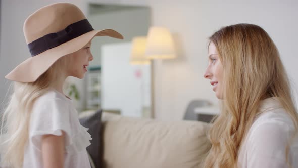 Cute Little Girl in Hat Twirling before Mother alt