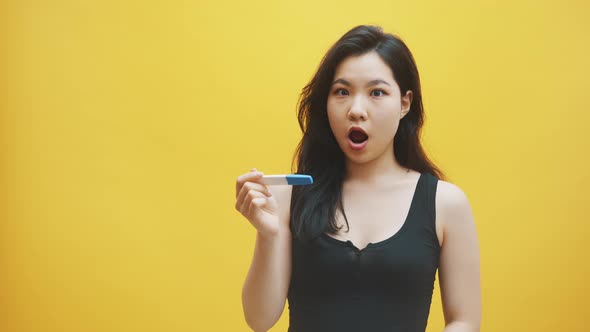 Impatient Young Asian Woman Looking at the Pregnancy Test Waiting for Results. Family Planing and alt