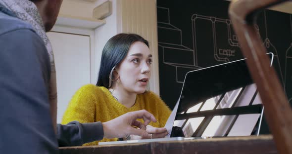 Two Young People Working Together with Laptop at Restaurant or Coworking alt