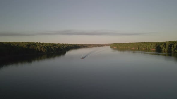 Aerial Birds Following View of a Hige River Bay and the Green Rainforest Under the Setting Sun