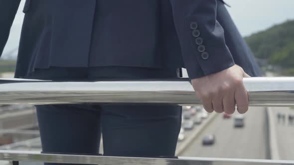 Close-up of Male Caucasian Hand Holding Bridge Fence. Unrecognizable Young Businessman Standing at alt