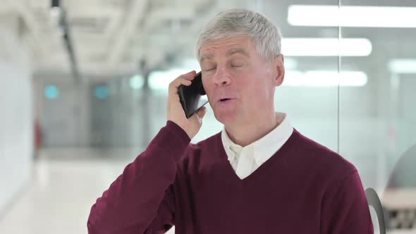 Cheerful Middle Aged Man Talking on Smartphone alt