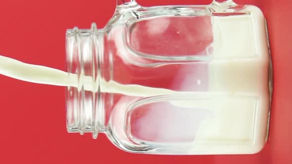 Vertical Video Slow Motion Closeup Shot of Cold Diary Milk Cold Beverage Drink Pooring Into Glass