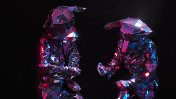 Actors in Shining Costumes Made of Mirrors with Heads of Horned Bulls Playfully Catching Each Other alt