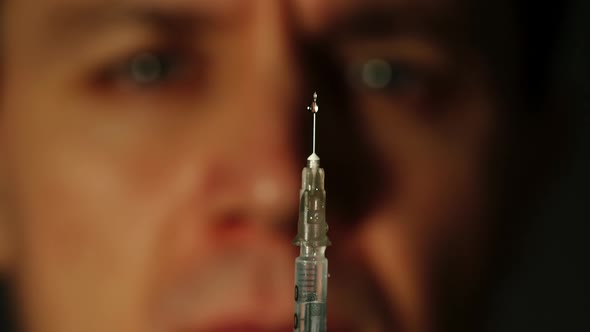 Portrait Of Drug Addict Looks At The Syringe alt