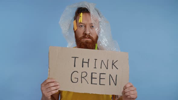 Adult man holding plate with inscription think green