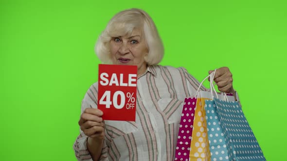Senior Woman Showing Up To 40 Percent Off Inscription Sign and Shopping Bags, Chroma Key Background alt