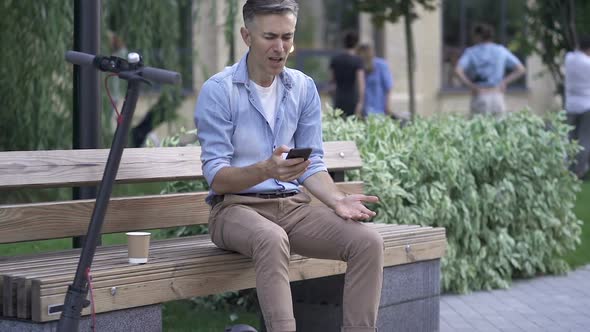 Angry man breaking up smartphone.