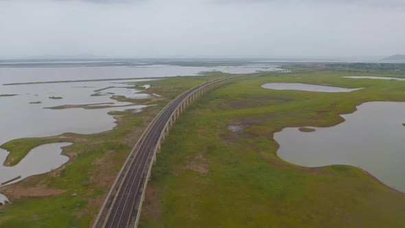 Aerial view of Thai local train on railway bridge at Pa Sak Jolasid Dam, the biggest reservoir alt