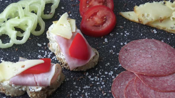 Cold appetizer. Cold cuts. Spicy food on black background. Different snacks 