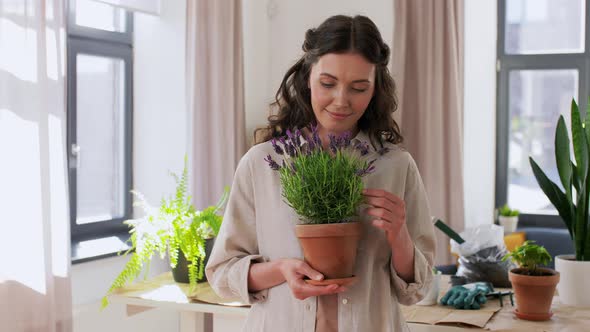 Happy Smiling Woman Holding Pot Flower at Home