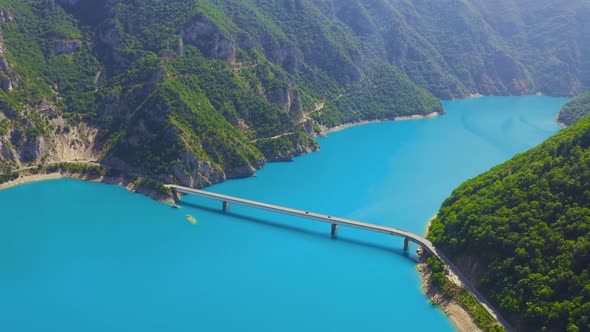 Aerial top view on Bridge over Lake Piva with turquoise water in mountains canyon in Montenegro alt