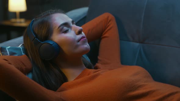 Young Woman is Lying at Home on the Couch with her Eyes Closed alt