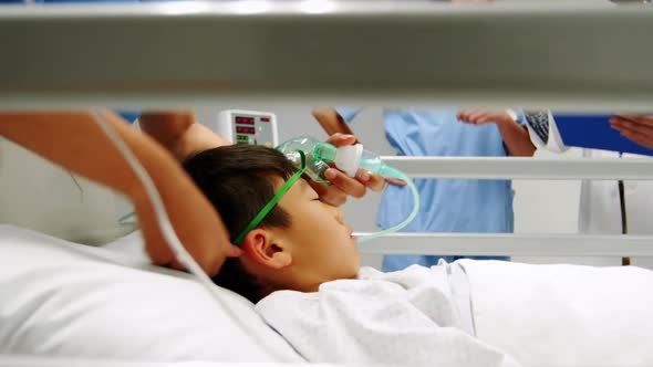 Nurse placing an oxygen mask and adjusting iv drip to patient in emergency room alt