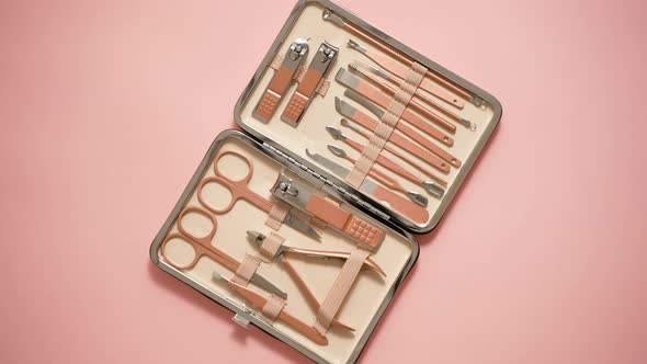 Pastel Cosmetic Set for Nail Care in a Case Placed on a Pink Background