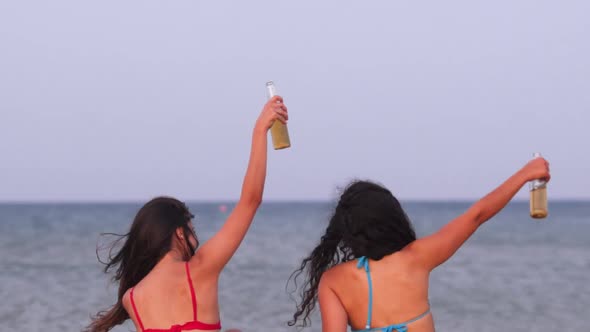 Young Hipster Women Partying at Beach and Drinking Beer