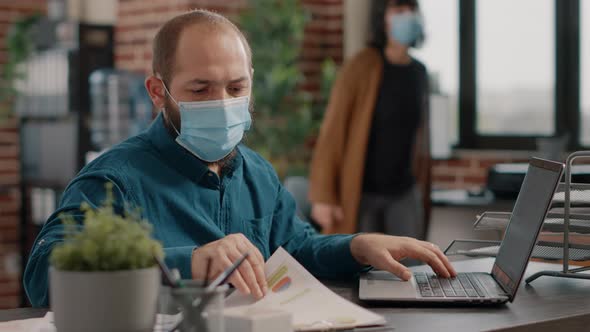 Entrepreneur Comparing Information on Papers and Laptop alt