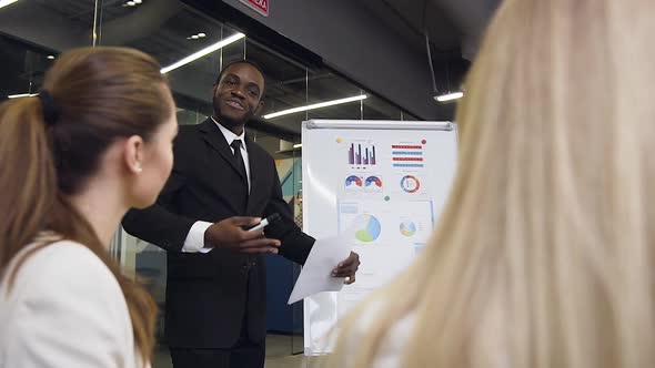 Businesswomen which Asking Different Questions to the Smiling Handsome Businessman alt