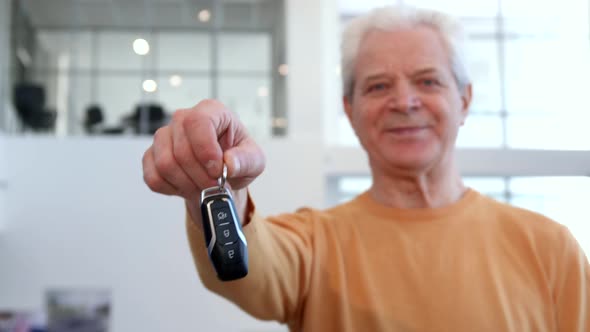 Senior Man Shakes Car Key in His Hand