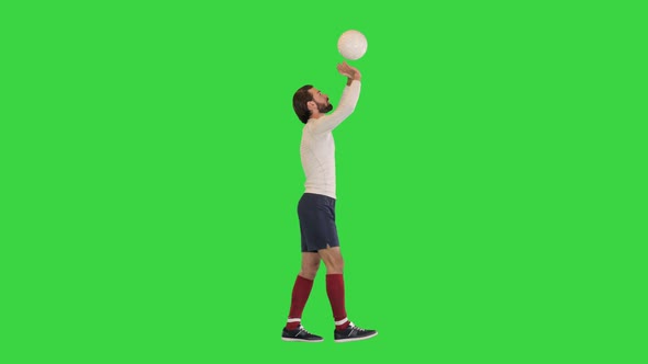Football Sportsman Walking and Bouncing a Ball in Hands Like a Volleyball Ball on a Green Screen alt