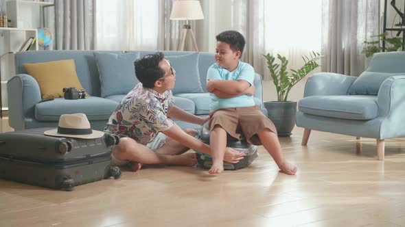 Asian Father And Son Are Helping To Close A Tightly Packed Suitcase. Family Preparing For Vacation alt