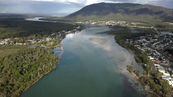 Wide establishing aerial shot featuring prime urban property right next to big beautiful blue river. alt