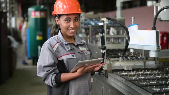 Portrait of a young black woman while working in production, slow motion alt