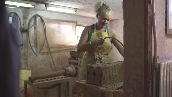 Female Potter Cutting Raw Pottery Clay on Pieces Using Bow Harp Cutter alt
