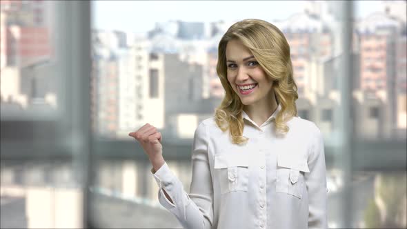 Business Lady in Office Pointing To the Back Behind with a Thumb Up alt
