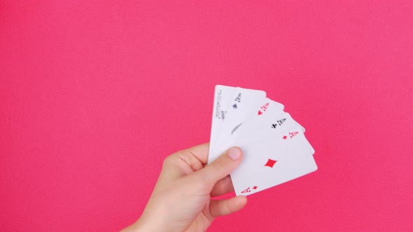 Five of kind Poker Game cards in gambler hand falling money bills pink background Lucky combination