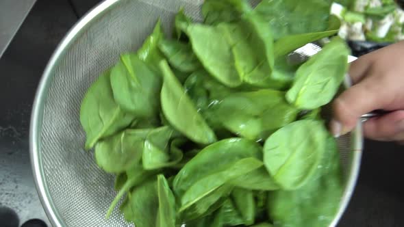 fresh healthy spinach leaves in colander, view from top
