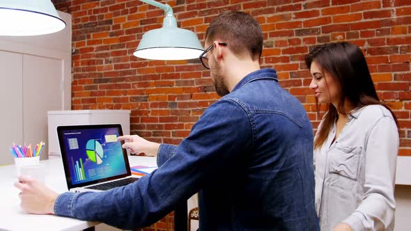 Group of executives discussing over laptop in the conference room alt