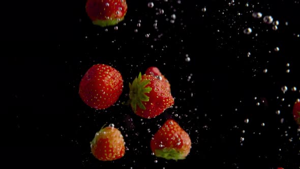 Strawberries Falling into Water Super Slowmotion, Black Background, lots of Air Bubbles, 4k240fps alt