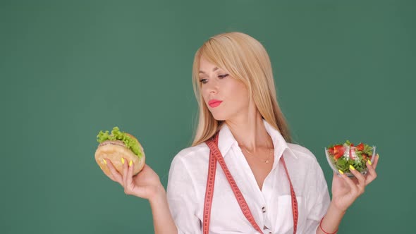 Healthy Woman Choosing Between Burger and Organic Food alt