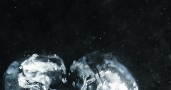 Blue Bubbles Rising Through Water Against Black Background alt