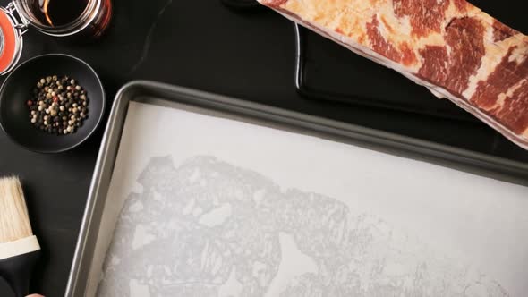 Time lapse. Raw bacon strips with fresh spices on a baking sheet. alt