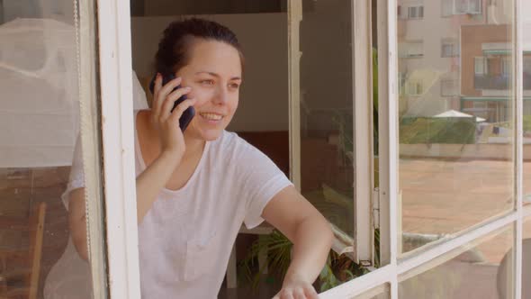 Brunette Woman Speak on the Phone and Look Out of the Window
