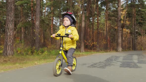 Kid Riding Balance Bike in Park alt