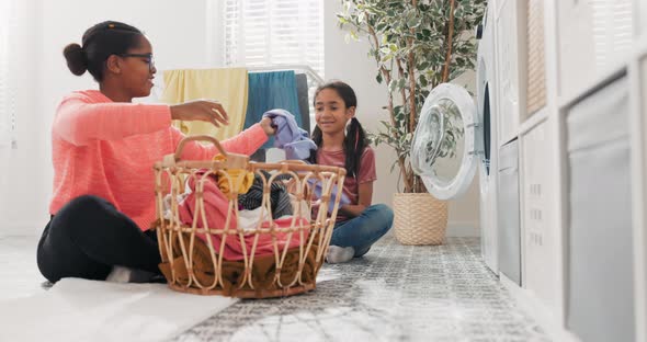 A Mom Spends Time With Daughter In Bathroom Laundry Room While Doing