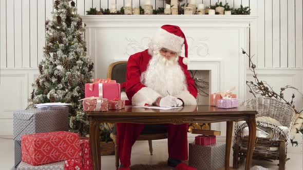 Santa Claus Checking His List of Presents alt