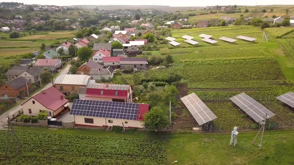 Aerial View of a Row of Blue Solar Panels Installed on the Ground in Residential Area alt