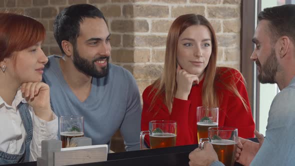 Group of Friends Talking Over Glass of Beer at the Pub