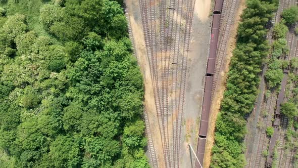 Straight down aerial drone footage of railway depot and railway tracks in the summer time
